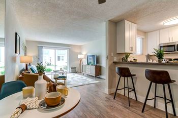 A living room and kitchen with a table and chairs 